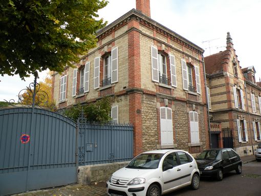  maison bourgeoise en pierre et brique avec des volets blancs